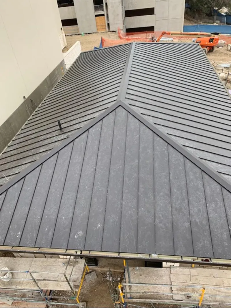 Commercial metal roof construction with crane equipment in Weymouth Town